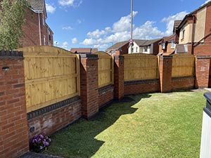 Garden boundary with arched tongue and groove fence panels