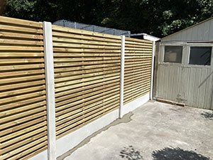 Concrete post base with batten style fencing